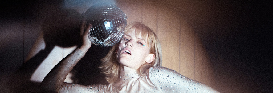 Joven sosteniendo una bola de espejos.