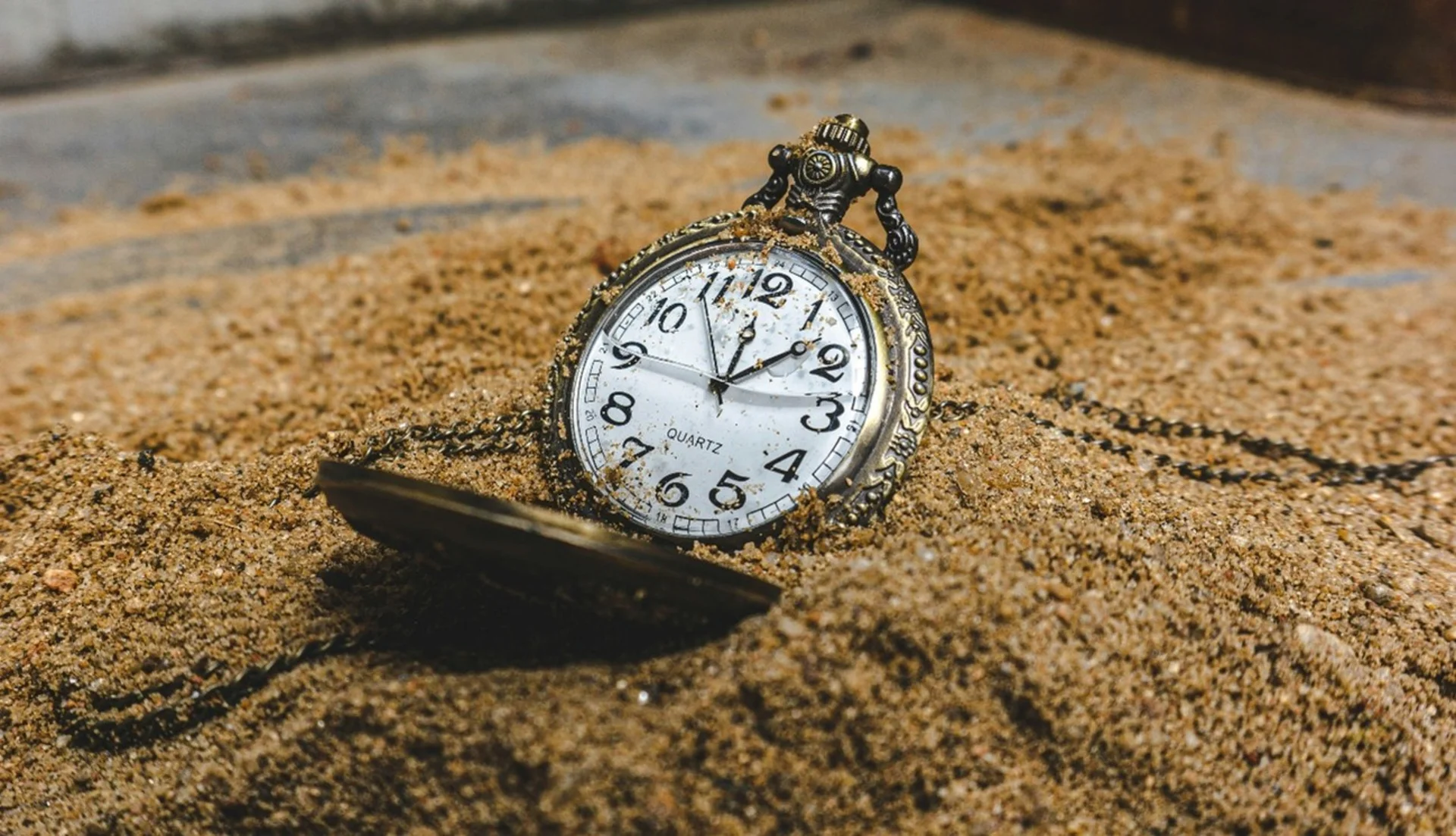 Reloj de bolsillo sobre la arena.